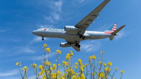 Un avión de American Airlines sobrevolando las instalaciones del Aeropuerto de El Prat, en Barcelona.