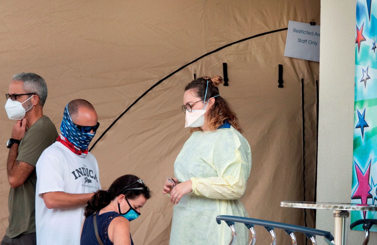 Personas con tapabocas esperan ingresar al Memorial Regional Hospital en Hollywood, Florida. 