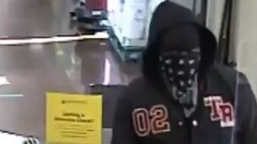 El momento que el ladrón entrega su nota al cajero.