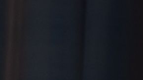 Niña triste y sola frente a ventana. Archivo