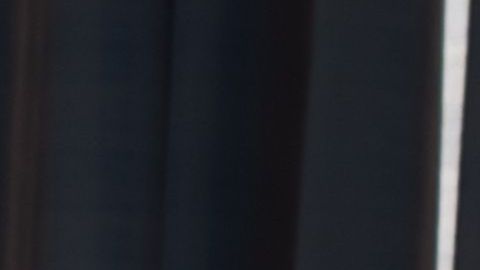 Niña triste y sola frente a ventana. Archivo