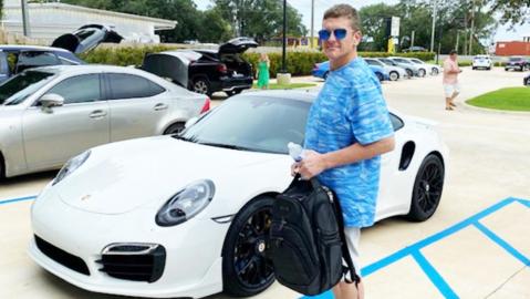 El hombre posó con el Porsche que compró con un cheque falso.