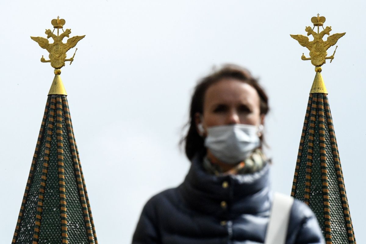 Una mujer utiliza mascarilla en Moscú, frente a las águilas de dos cabezas, el símbolo nacional de Rusia. 