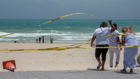 People enjoy the waves on the closed beach in Miami beach, Florida, USA, 01 August 2020. Hurricane Isaias weakened and lost intensity after passing over the Bahamas and it still on course to arrive off the coast of Florida Saturday night, according to the National Hurricane Center.