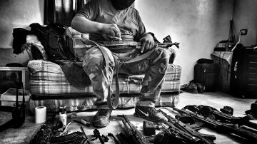 Un miembro del cartel de Sinaloa limpia sus armas.