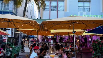 Una pareja disfrutando de unas bebidas en un bar de Miami Beach.
