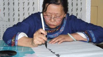 Una mujer dibuja los caracteres de este lenguaje escrito chino exclusivo para las mujeres.