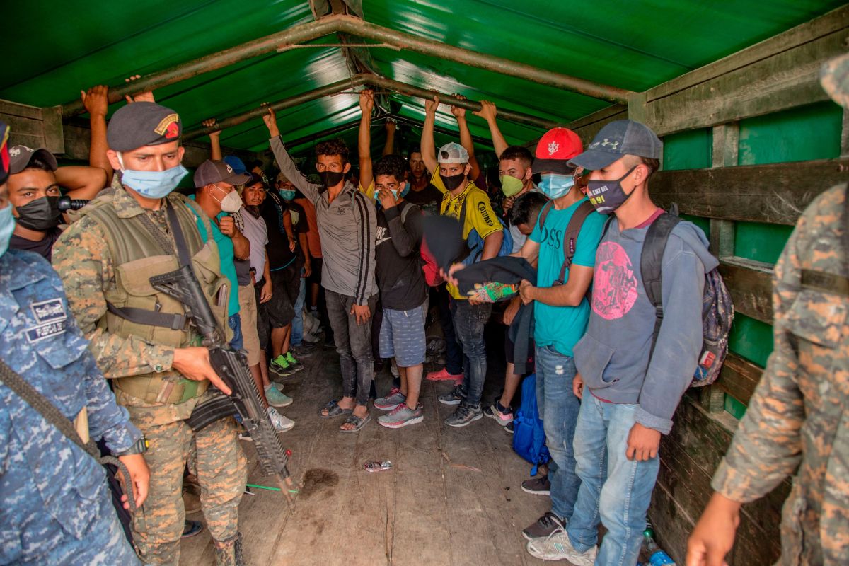  Un grupo de migrantes suben a un camión del ejército de Guatemala que los regresaría a la frontera entre Honduras y Guatemala, este sábado, en Morales.