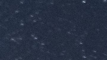 Un meteoro cruza el cielo nocturno junto a la Vía Láctea.