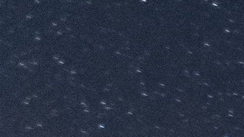 Un meteoro cruza el cielo nocturno junto a la Vía Láctea.