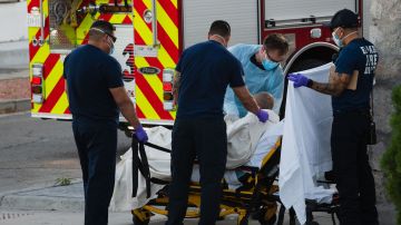 Trabajadores sanitarios recogen a un enfermo con COVID-19 en El Paso.