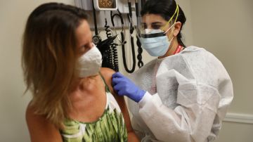 Una mujer administrando una vacuna contra la gripe en un centro CVS en Miami.