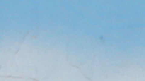 Un hombre camina ante un mural con la bandera de Irán en Teheran.