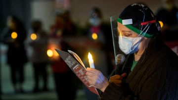 Una enfermera lee nombres de trabajadores de la salud fallecidos por COVID-19 en Los Ángeles.