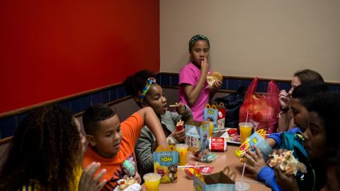 RIO DE JANEIRO, BRAZIL - AUGUST 11:  Children from the Cantagalo 'favela' community enjoy happy meals at McDonalds before heading to the Olympic Rugby 7's on August 11, 2016 in Rio de Janeiro, Brazil. A small group of children were surprised with tickets to the Olympics after staff and volunteers from their English language school the Caminhos Language Centre, arranged to buy tickets for them. The kids were given Olympic merchandise bags, a trip to McDonalds and tickets to a session at the Olympic Rugby 7's event. Generally, tickets to the Olympics are out of reach for many Brazilians, families from underprivileged areas such as favelas have very little opportunity to see  the Olympics live. .  (Photo by Chris McGrath/Getty Images)