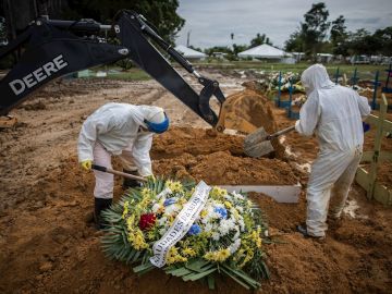 Trabajadores entierra a muertos por COVID-19.