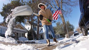 FORT WORTH, DALLAS TEXAS: Honey Russell quita la nieve de la acera de su casa para poder transitar libremente después de la tormenta histórica en Fort Worth.