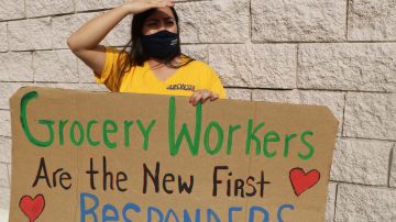 Una trabajadora protesta afuera de la tienda Food 4 Less en Long Beach.