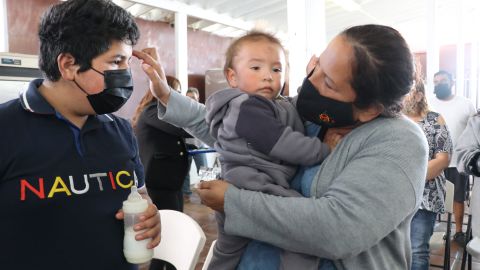 La señora Sandra Valencia le impone la ceniza y hace la señal de la cruz en la frente de su hijo Michael,
