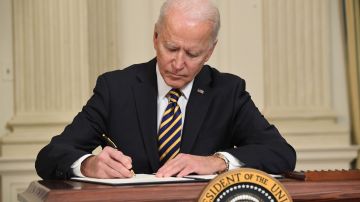Joe Biden firmando en la Casa Blanca