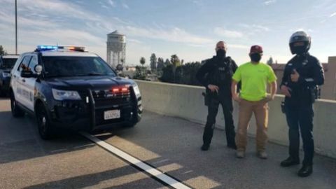 Oficiales de la Policía junto al hombre que salvó al suicida.