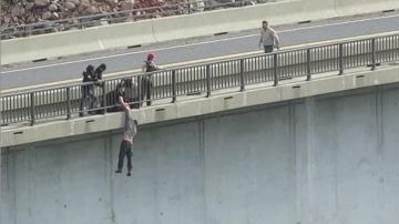 El agente Andrew Long sostiene en el aire a un suicida que saltó de un puente en California.
