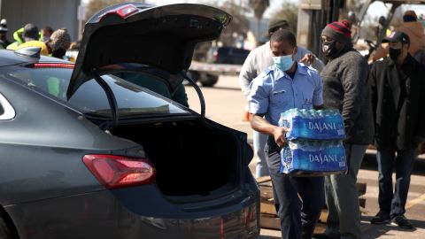 Un voluntario carga agua en un automóvil durante una distribución masiva de agua en Houston.