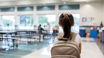 Una estudiante de primaria entra a la cafetería de la escuela.