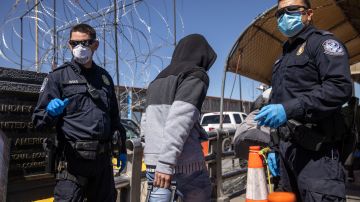Solicitantes de asilo cruzan un puente internacional de México a EE.UU. el 17 de marzo de 2021 en Ciudad Juárez.