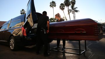 Dos empleados mueven el ataúd de una persona que murió tras contraer COVID-19, el 15 de enero de 2021 en El Cajon, California.