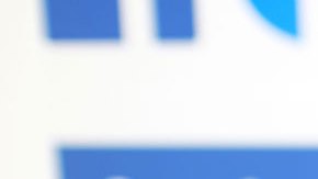 Mano sosteniendo teléfono celular con imagen de Facebook