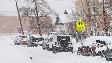 Hombre retira nieve de auto