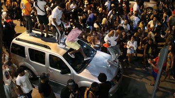 Jóvenes subiéndose a un vahículo en Miami Beach