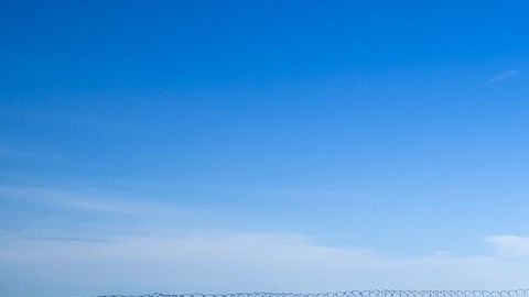 Migrantes en muro fronterizo