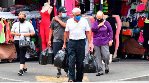 Personas con mascarilla caminando por la calle