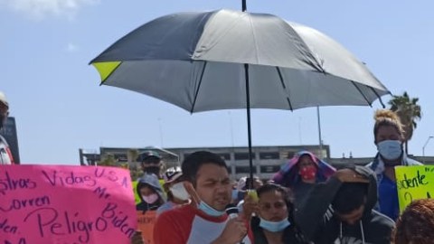 Refugiados marchan y oran en la frontera en busca de un asilo.