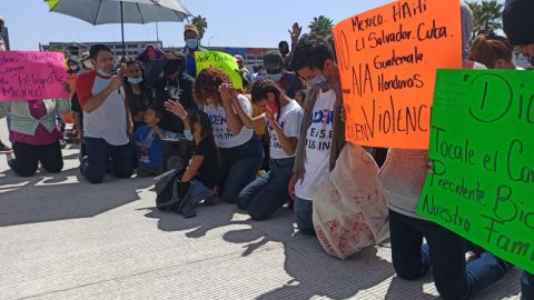 Refugiados marchan y oran en la frontera en busca de un asilo.