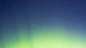 Esta es una aurora sobre Kirkjufell y las cascadas aledañas en Islandia, de noche.