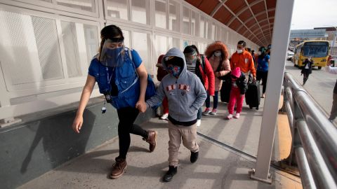 Familias migrantes cruzan la frotnera para revisar sus pedidos de asilo.