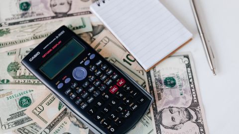 Calculadora y billetes de dólar