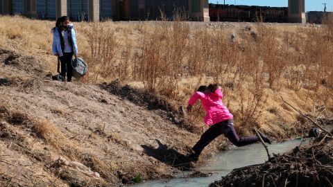 Una niña migrante salta para cruzar el Río Bravo para llegar a El Paso, desde Ciudad Juárez.