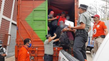 Agentes de la guardia nacional detienen a un grupo de migrantes que viajaba en un camión por México