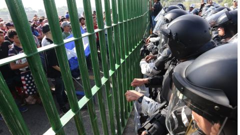 Policias y migrantes en frontera