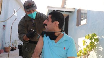 Arturo Montiel recibe la vacuna del agente y paramédico del sheriff, Steve Pratt. / fotos: Jorge Luis Macías.