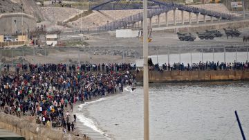 Migrantes marroquíes intentan cruzar la frontera de Marruecos al enclave español de Ceuta.