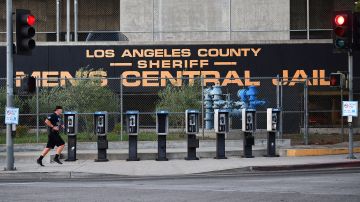 A man jogs past a row of telephone booths in front of the LA County Men's Central Jail on May 11, 2020 in Los Angeles, California. - Due to the coronavirus pandemic, more than 5,000 inmates have been released from county jails in an effort to slow the spread of the coronavirus but cases in the jail sysyem spiked 60% in the span of a week, according to numbers reported today by Sheriff Alex Villanueva. (Photo by Frederic J. BROWN / AFP) (Photo by FREDERIC J. BROWN/AFP via Getty Images)