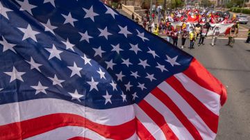 Una bandera de Estados Unidos sobrevuela la marcha del Primero de Mayo en Los Ángeles.