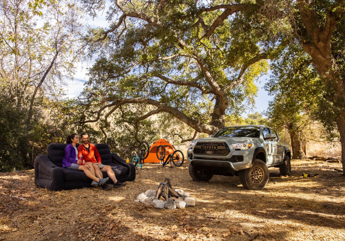 Foto de la nueva Toyota Tacoma 2022 junto a dos personas en un campamento