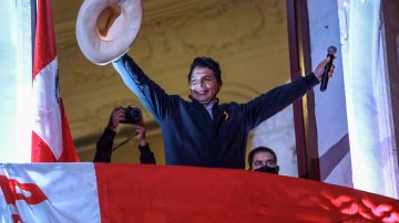 Pedro Castillo saluda a seguidores desde un balcón de la sede de su partido Perú Libre.