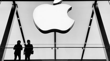 Foto de dos personas conversando junto a un edificio con el logo de Apple